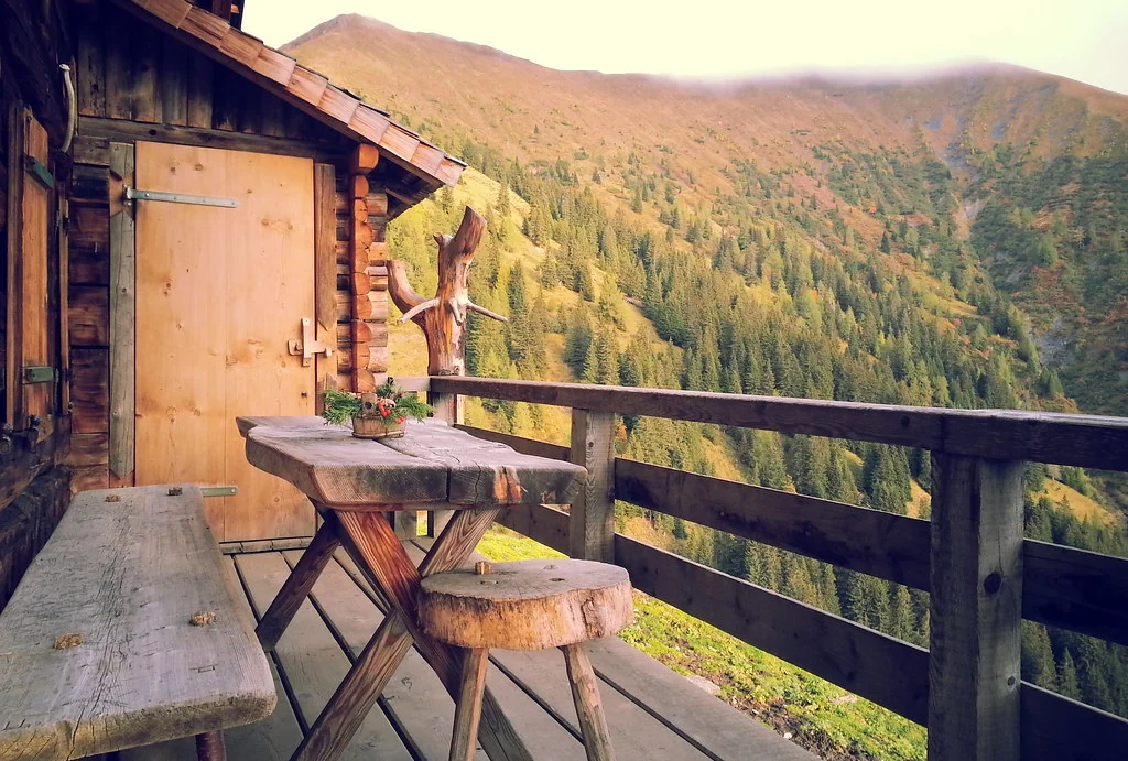 Deck table and railing looking out over a wooded hillside
